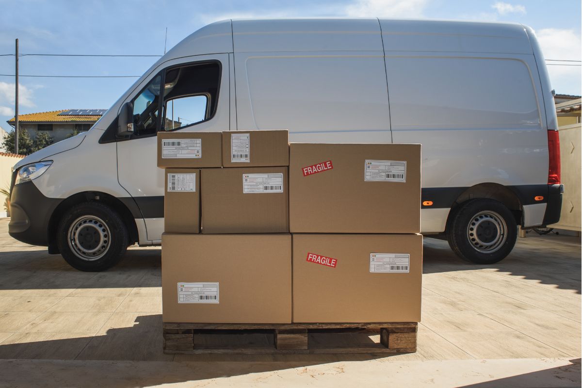Pallet of boxed goods in front of a courier van